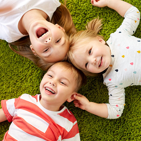 Three Children Laughing in the Grass